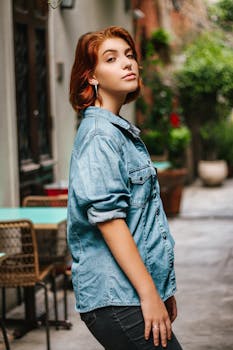 一位美丽的女人穿着牛仔衬衫，在圣保罗迷人的街道上随意摆着姿势