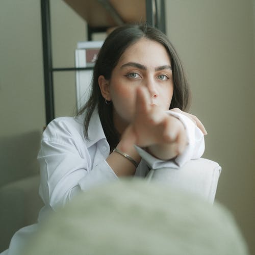 Photo of a Young Woman Stretching Her Arm Toward the Camera 