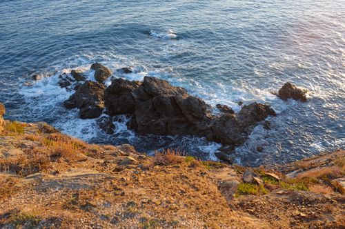 Free Scenic view of the Spanish coast with waves breaking on rocks during sunset. Stock Photo