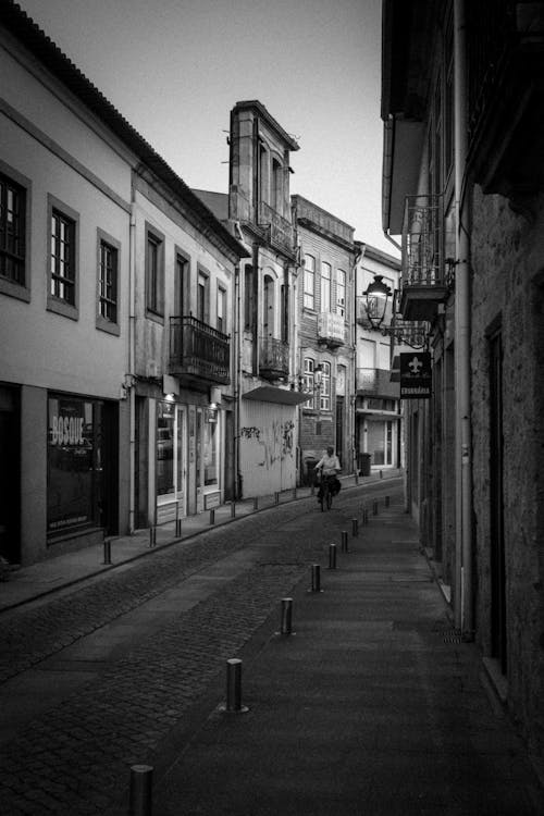 A black and white photo of a narrow street