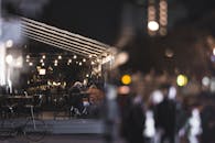 基辅一家舒适的街头咖啡馆在夜间被环境灯光照亮，营造出轻松的城市氛围