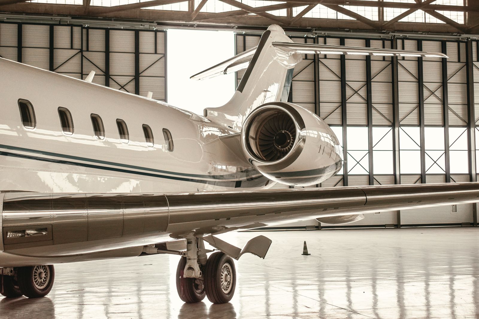 A sleek private jet parked inside a modern hangar in Paris