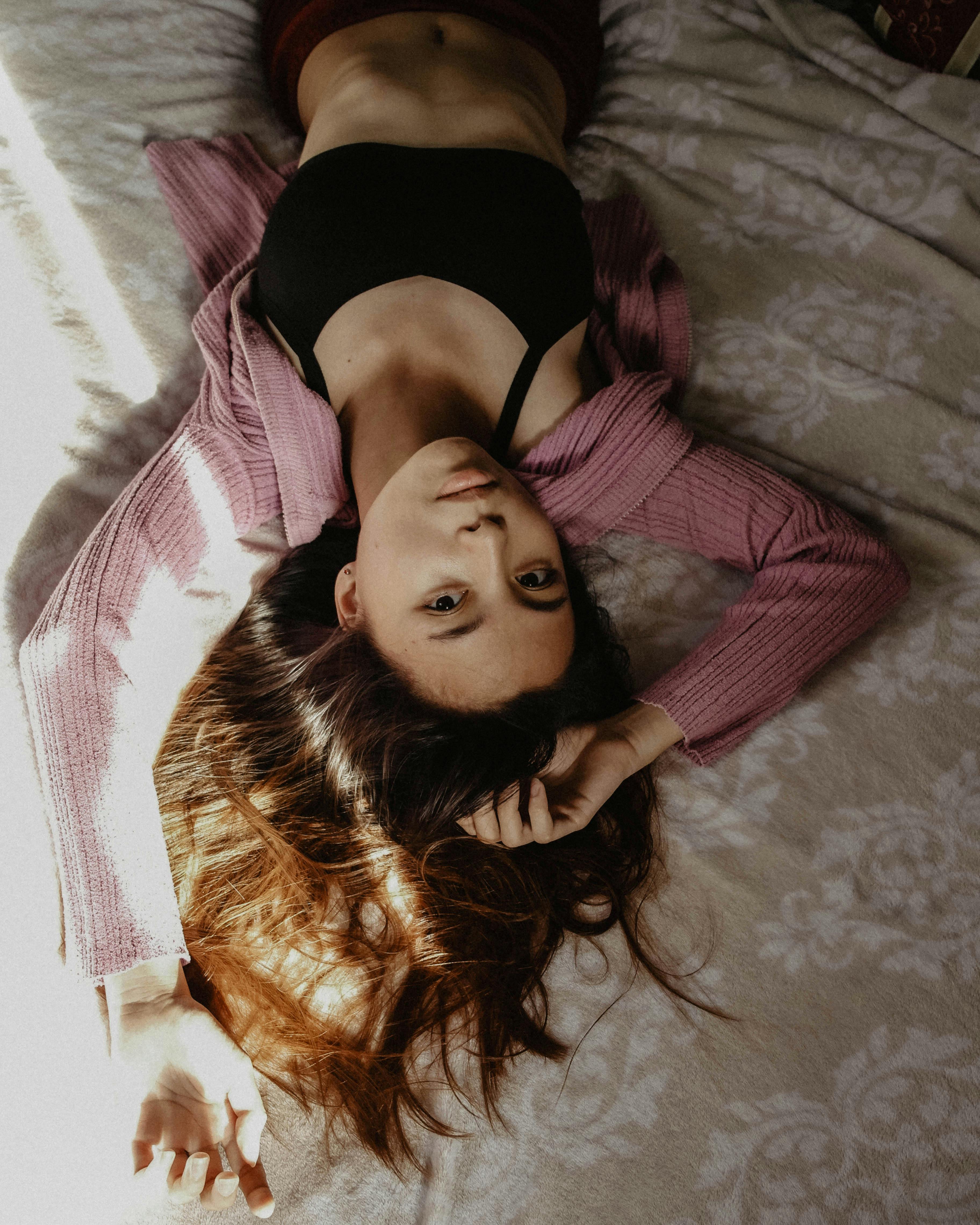 brunette woman wearing black bra and blue shorts lying on the bed face up  using mobile phone touching blank screen Stock Photo - Alamy