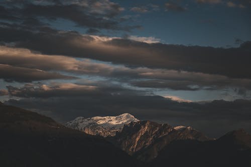 A mountain range with clouds and dark skies