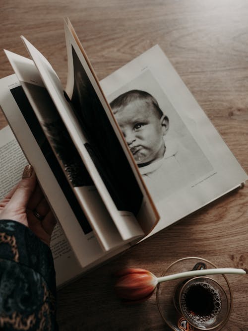 A person holding a book with a photo of a baby