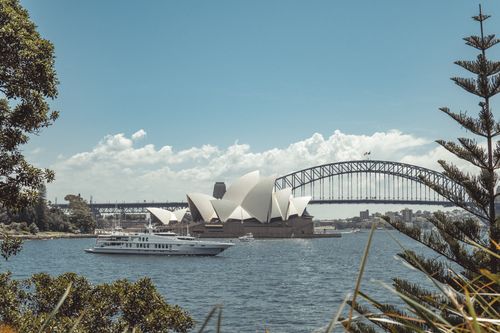 Free Beautiful view of Sydney Opera House and Harbor Bridge with a yacht sailing in the foreground. Stock Photo