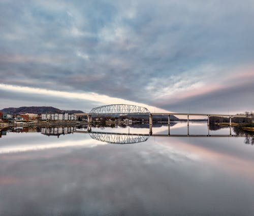 A bridge over a river with clouds in the sky