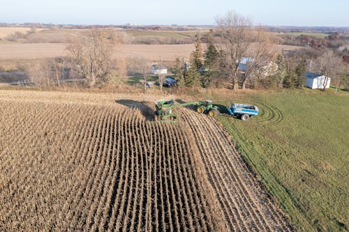 Aerial view of a tractor and a combine harvesting corn
