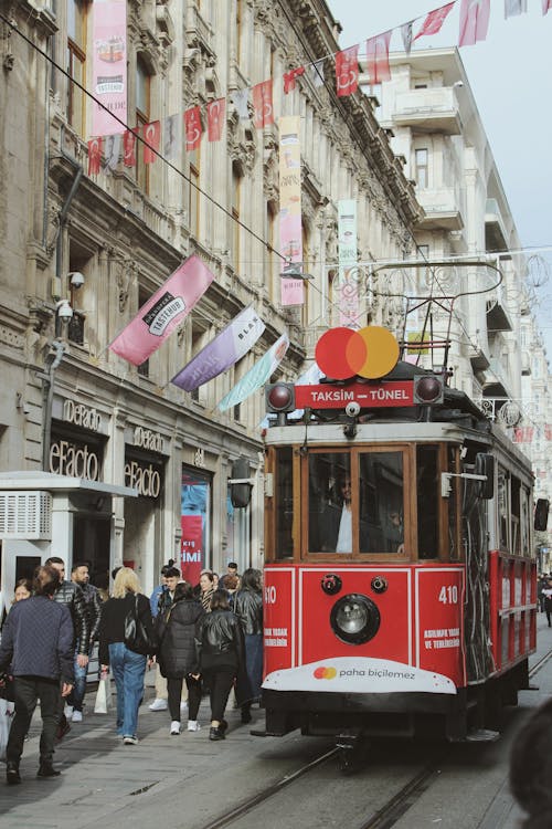 A red and white tram is traveling down a city street