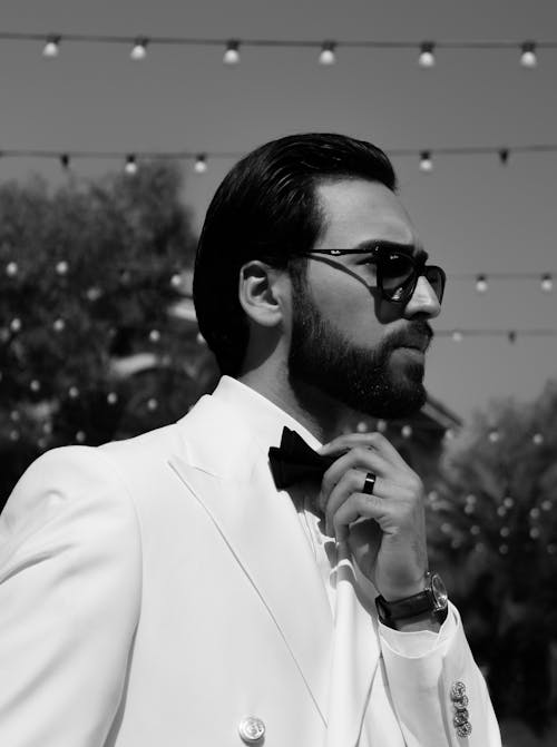 A man in a white suit and sunglasses