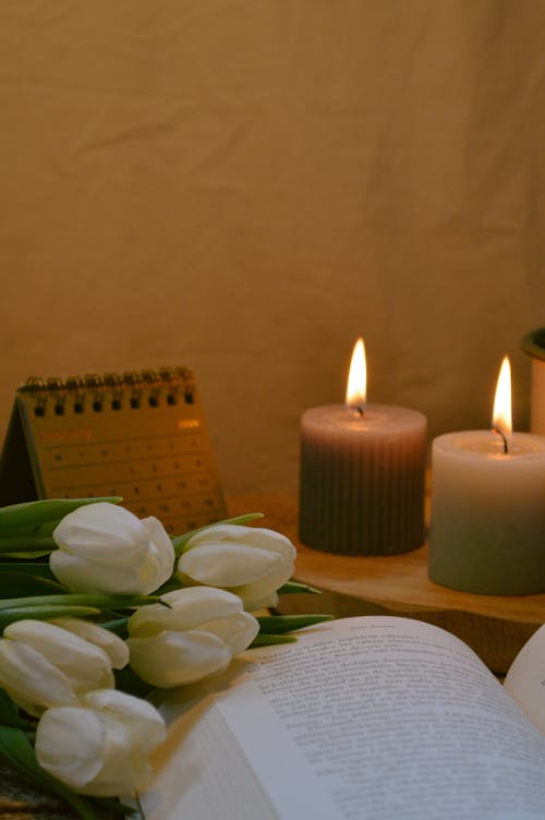 A book with a candle and flowers on it
