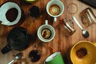 Artistic top view of empty coffee cups with spilled stains on a wooden table.