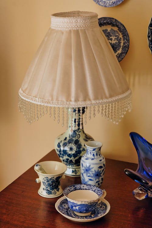 A table with a lamp and a blue and white china plate