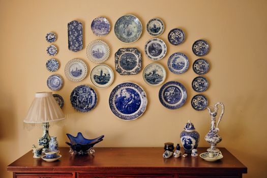 Elegant arrangement of vintage blue ceramic plates on a wall with complementing decor.