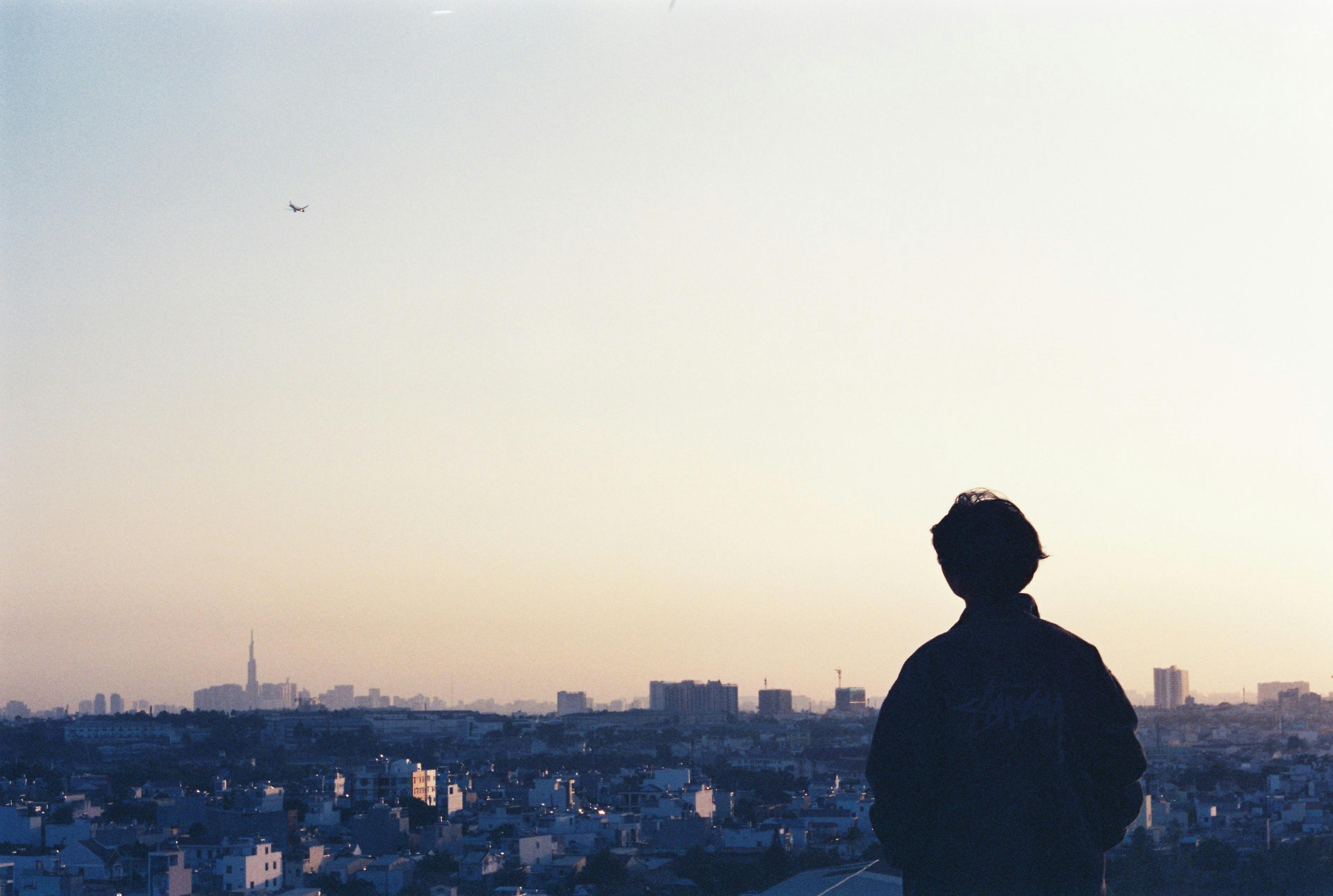 城市天际线映衬着日落，一个人的轮廓唤起平静与反思