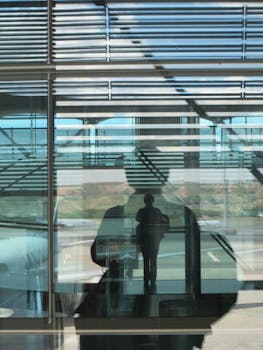 Silhouette reflections on glass at Madrid Airport capturing abstract urban textures.