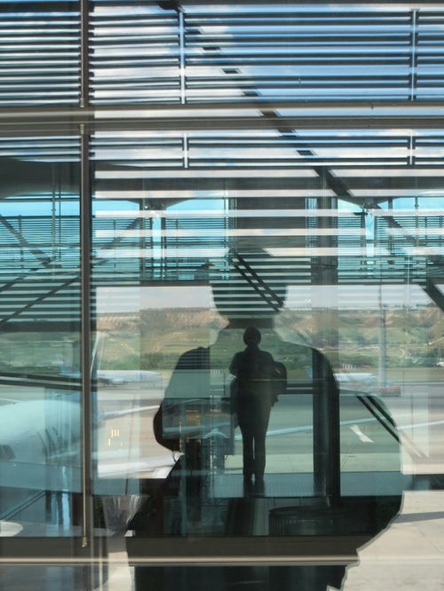 Free Silhouette reflections on glass at Madrid Airport capturing abstract urban textures. Stock Photo