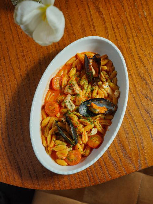 Free Top view of Italian gnocchetti with mussels and tomatoes in a rustic setting. Stock Photo