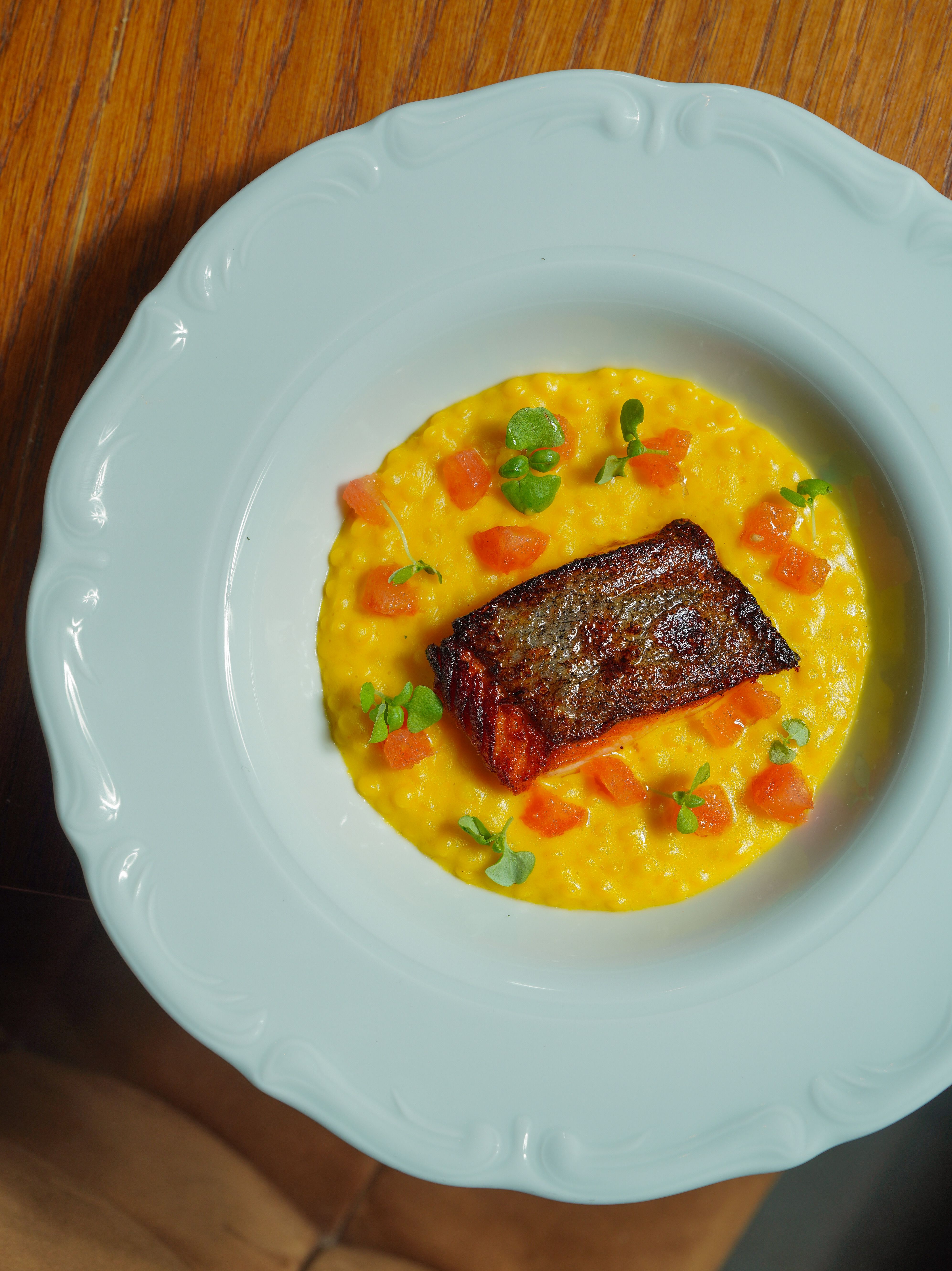 Delicious gourmet salmon served on creamy risotto with fresh vegetables.