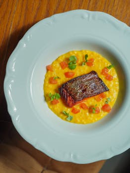 Delicious gourmet salmon served on creamy risotto with fresh vegetables.