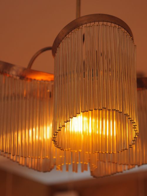 Free A close-up of a warm, illuminated vintage chandelier with intricate design. Stock Photo