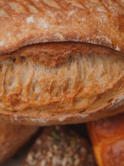A close up of a loaf of bread with other breads