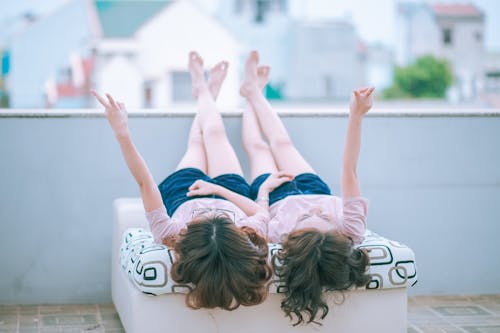 Two Person Lying on White Bed