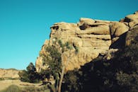 在加利福尼亚州晴朗的蓝天下，矗立着雄伟的岩石结构和独特的约书亚树