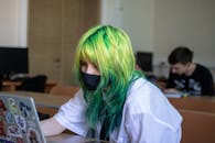 High School Student with Dyed, Green Hair Sitting by Desk