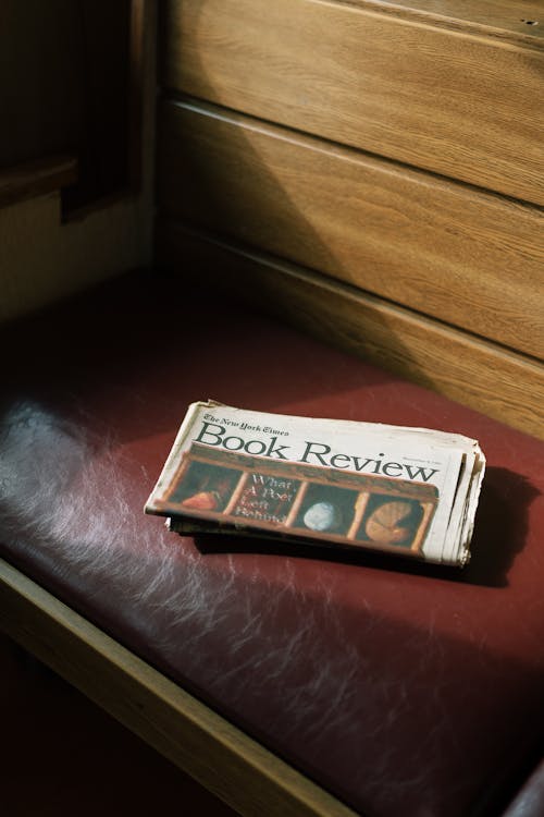 A newspaper sits on a bench in a church