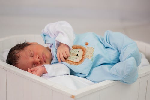 Free A newborn baby sleeping in a white box Stock Photo