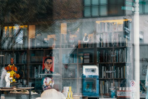 A reflection of a book store window with a man in a chair