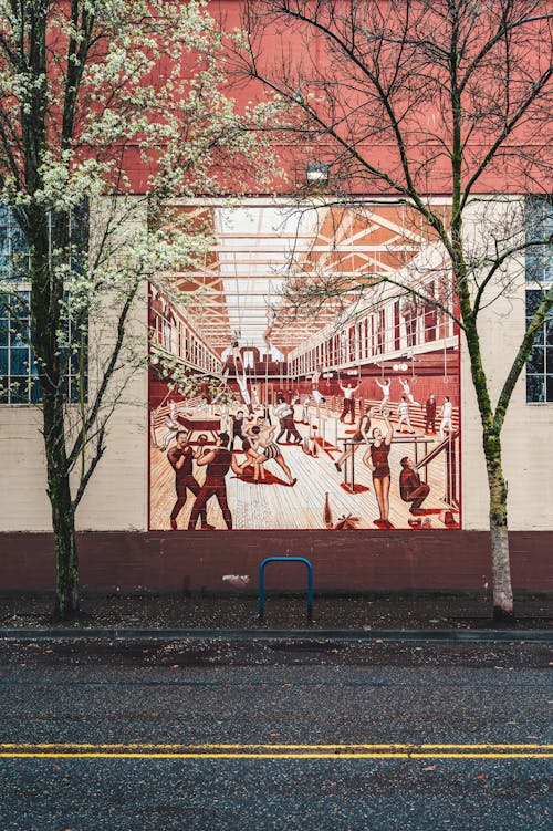 A mural on the side of a building with people walking