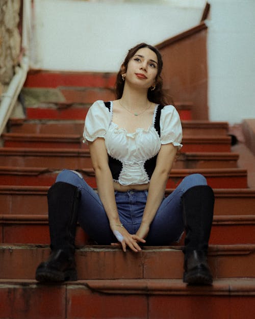 A woman sitting on some stairs with her legs crossed