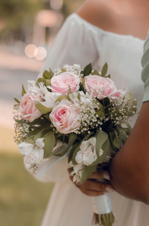 A bride holding a bouquet of pink and white flowers