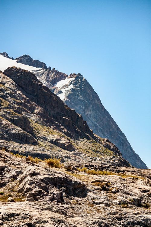 Free A breathtaking view of a snowcapped mountain peak under clear blue skies. Stock Photo