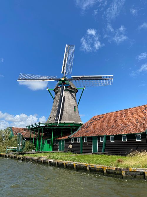 Free Scenic view of a traditional Dutch windmill by the water in Amsterdam. Stock Photo
