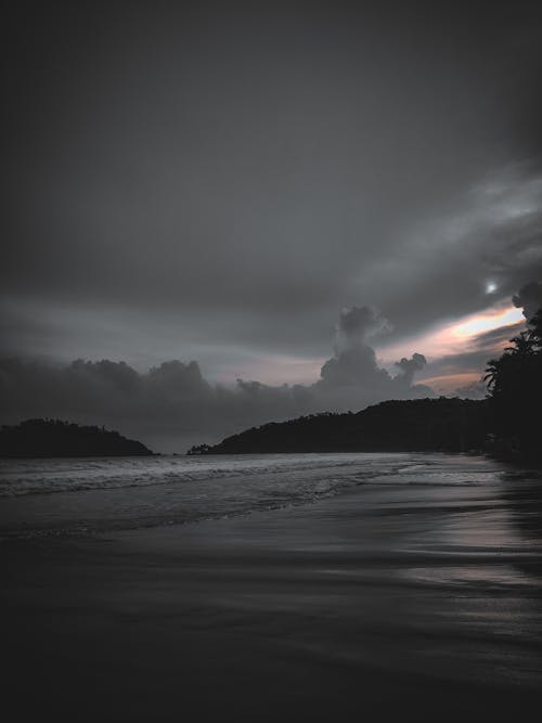 A black and white photo of the ocean at night