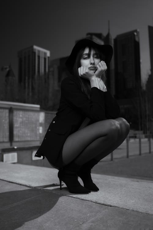A woman in black and white is crouching down