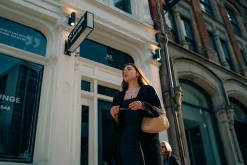 A woman walking down the street in front of a building