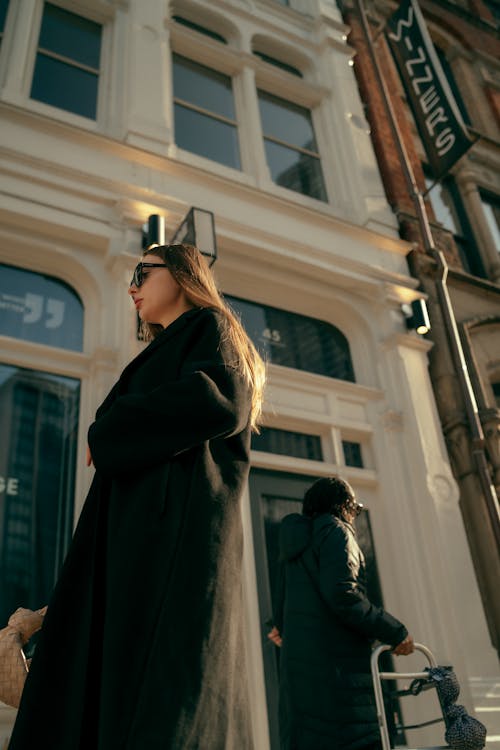 A woman in a black coat walking down the street