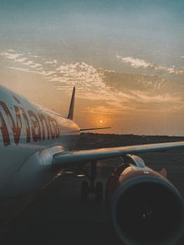 A serene sunset view of an airplane on the tarmac, perfect for travel themes.