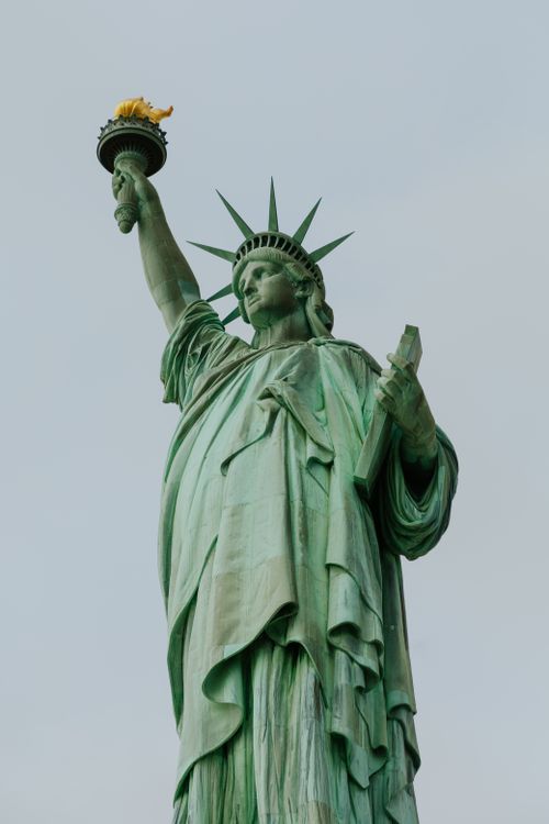 Free The Statue of Liberty standing majestically against a clear sky, symbolizing freedom and democracy. Stock Photo