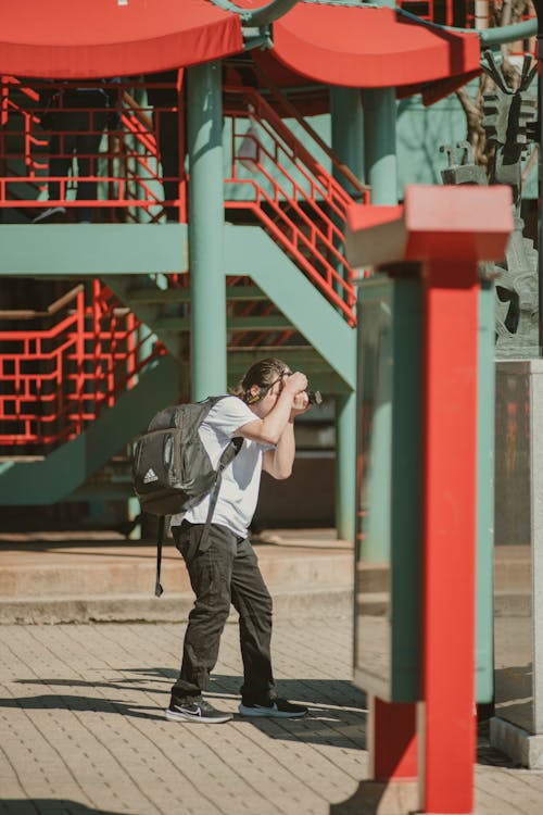 A man taking a picture of a red building