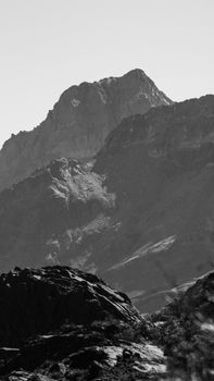 Stunning monochrome view of rugged mountain peaks under a cloudy sky.