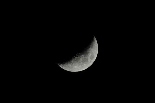 Free Capture of a crescent moon with detailed surface against a black sky background. Stock Photo