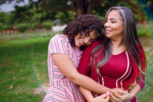 Woman Wearing Pink Dress Hugging Another Woman