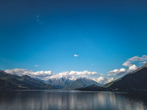 A lake with mountains in the background and blue sky