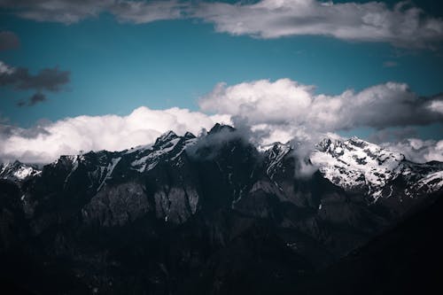 A photo of a mountain range with clouds