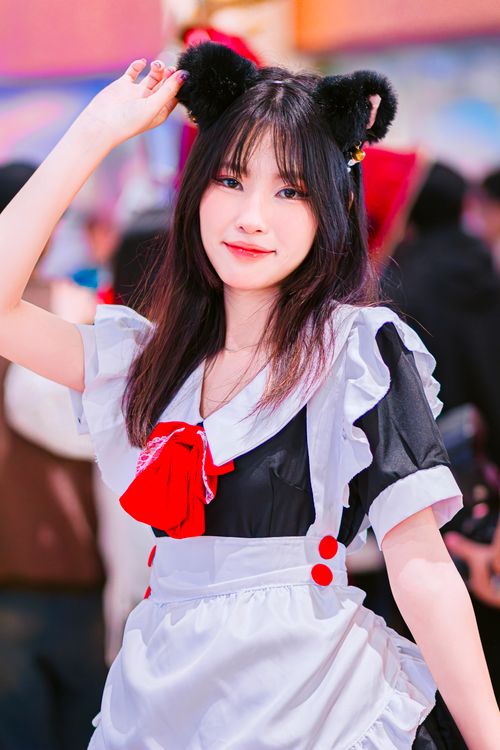 Free Young woman cosplayer dressed as a maid at an anime convention, showcasing cute fashion. Stock Photo